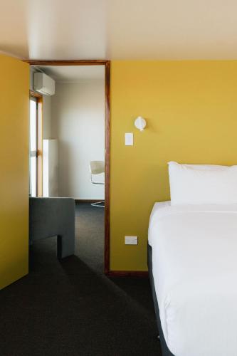 a bedroom with a bed and a desk and a mirror at The Mayfair in Hastings