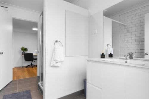 a white kitchen with a sink and a mirror at Family Getaway in Belmont in Belmont