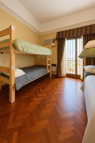 a bedroom with two bunk beds and a wooden floor at Rodex Hostel Tucuman in San Miguel de Tucumán