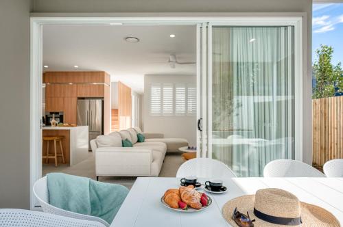 a living room with a table with a plate of food at Essence Peregian Beach in Peregian Beach