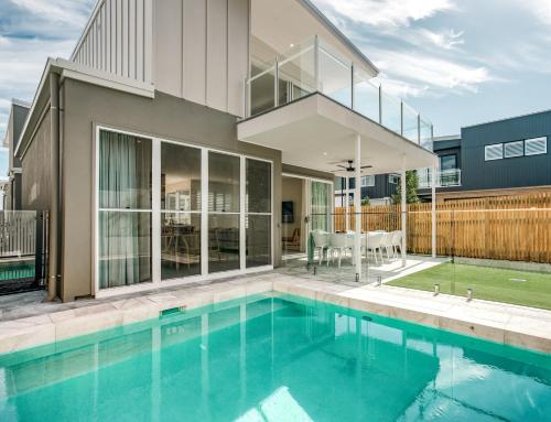 a house with a swimming pool in front of a house at Essence Peregian Beach in Peregian Beach