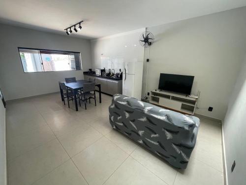 a living room with a couch and a table with a television at Casa de Lazer com piscina in Pirassununga
