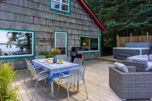 a patio with a table and chairs and a grill at Sandy Beachfront, Hot Tub, Pet-friendly, Kayaking 
