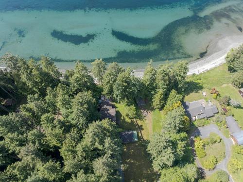 an aerial view of a house with trees and water at Sandy Beachfront, Hot Tub, Pet-friendly, Kayaking 