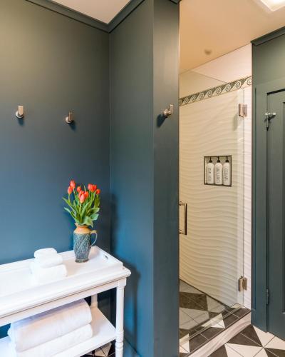 a bathroom with blue walls and a white table with flowers at Sandy Beachfront, Hot Tub, Pet-friendly, Kayaking 
