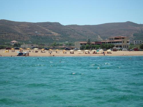 a beach with umbrellas and people on the beach at Gramvoussa Bay in Kissamos
