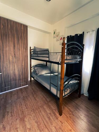 two bunk beds in a room with a wooden floor at Schwesti's Lodge in Baguio