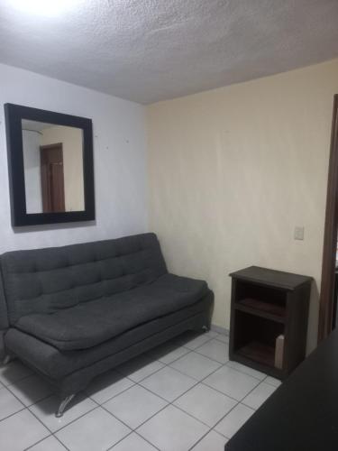 a living room with a couch and a mirror at Apartment bello y tranquilo in Mexico City