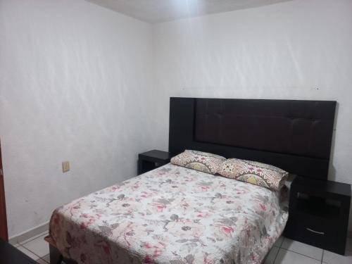 a bedroom with a bed with a black headboard at Apartment bello y tranquilo in Mexico City