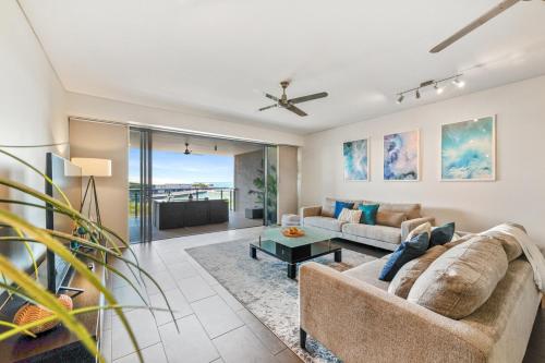 a living room with a couch and a table at Delightful Waterfront Lagoon Views & Restaurants in Darwin
