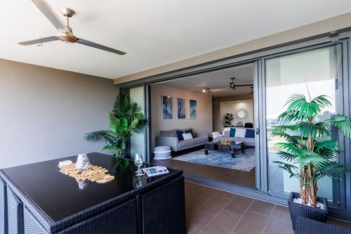 a living room with a ceiling fan and a living room at Delightful Waterfront Lagoon Views & Restaurants in Darwin