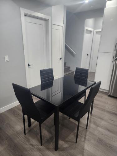 a black dining room table and chairs in a room at Home in Northwest Calgary in Calgary