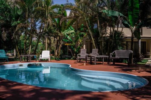 a small swimming pool with chairs and a table at Seahouse Beachfront B&B with Pool in Bocas del Toro