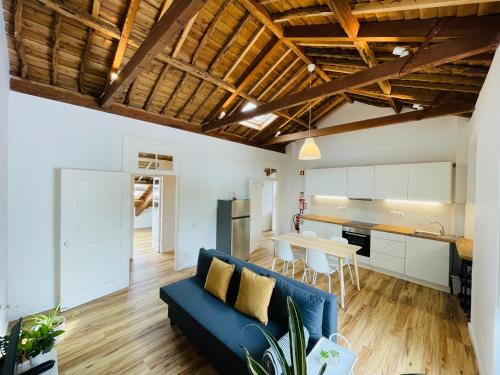 a living room with a blue couch and a kitchen at Casa da Arquitectura - Texturas in Angra do Heroísmo