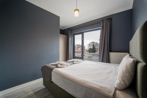 a bedroom with a bed with a large window at Centrum Residence in Ankara