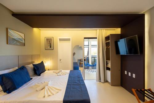 a bedroom with a large bed with a flat screen tv at Aira Hotel in Sobral