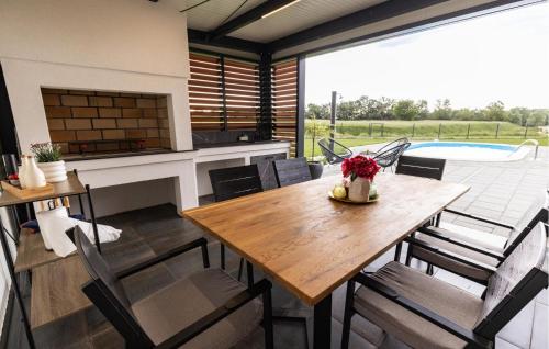 a dining room with a table and chairs and a pool at Stunning Home In Pitomaca With Wifi in Pitomača
