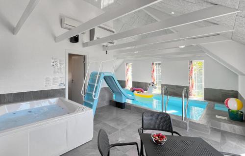 a kids room with a swimming pool and a slide at Pet Friendly Home In Ringkøbing in Klegod