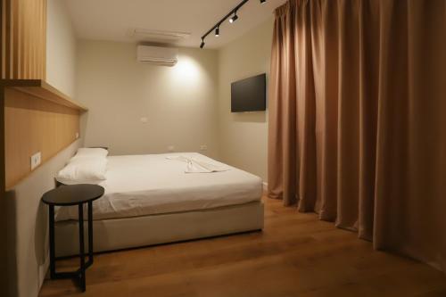 a bedroom with a bed and a television and a stool at Hotel Relax City Center in Tirana