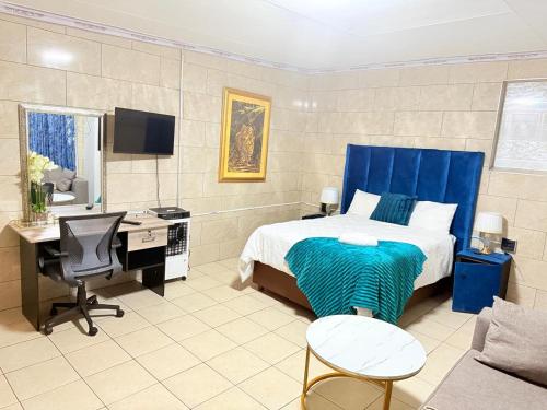 a bedroom with a bed and a desk and a computer at Whizzy lifestyle lodge in Duvhapark