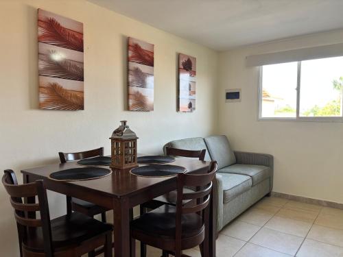a living room with a table and a couch at Hacienda Apartments near the beach in Oranjestad