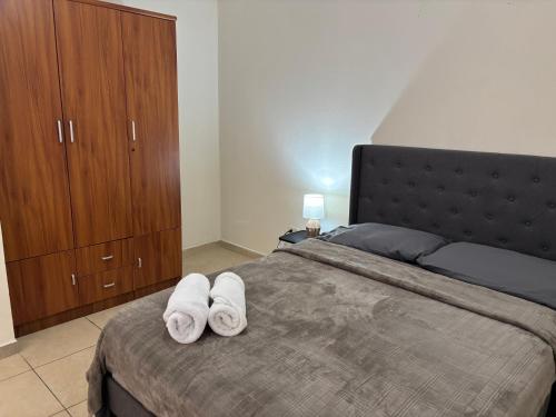 a bedroom with a large bed with towels on it at Hacienda Apartments near the beach in Oranjestad