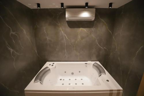 a bathroom with a sink and a light on a wall at Hotel Relax City Center in Tirana