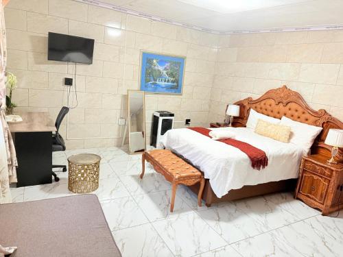 a bedroom with a bed and a desk and a television at Whizzy lifestyle lodge in Duvhapark