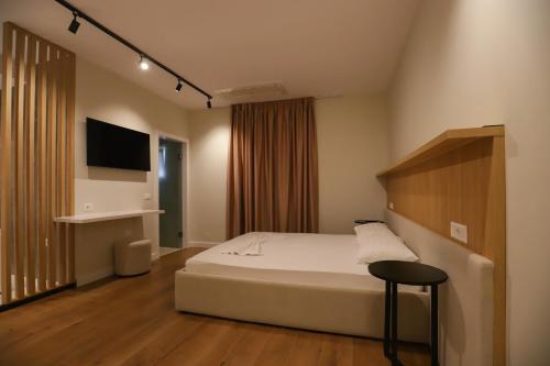 a bedroom with a bed and a chair and a television at Hotel Relax City Center in Tirana