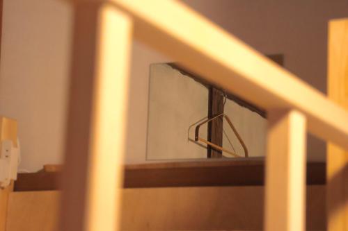 a close up of a wooden staircase with a mirror at KARASUYA GuestHouse in Takasaki