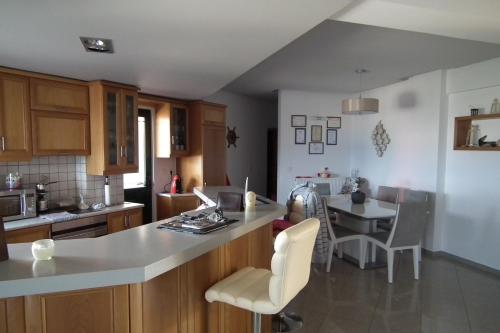 a kitchen with a counter and a table with chairs at Gramvoussa Bay in Kissamos
