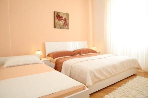 a bedroom with two beds and a window at Apartments Vila&Zora in Vodice