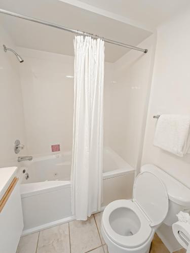 a white bathroom with a toilet and a shower at Treetop- Timberline Terraceunit29- Four Seasons in Four Seasons