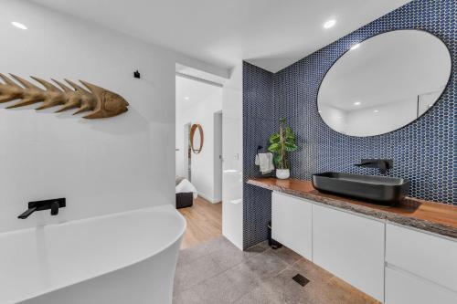 a bathroom with a sink and a mirror at Bellvilla - Bluebonnet Suite in Merimbula
