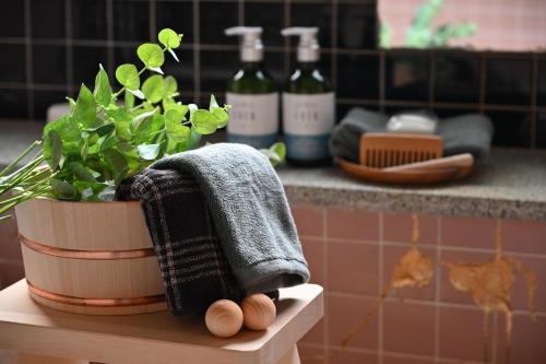 a towel and a plant on a shelf in a bathroom at Hideaway Tabaki in Echizen-shi