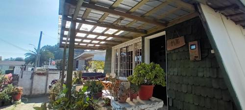 awning on the side of a house with plants at Cabaña Los Corsarios in El Quisco