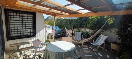 a patio with hammocks and a table and chairs at Cabaña Los Corsarios in El Quisco
