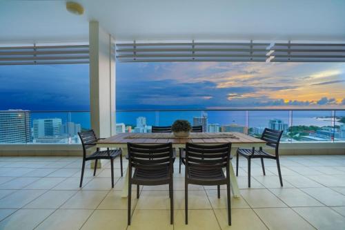 una mesa de comedor y sillas en una habitación con vistas en Sub-Penthouse Stunner Harbour Views & Pool, en Darwin