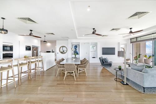 Una sala de estar y una cocina con mesa y sillas. en Ultimate Penthouse Majestic Harbour Views & Pool, en Darwin