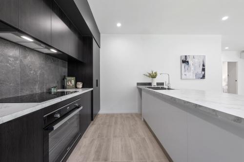 a kitchen with black cabinets and white counter tops at St Crispins Villa 3 with private heated pool in Port Douglas