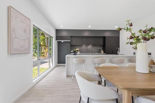 a kitchen and dining room with a wooden table and chairs at St Crispins Villa 3 with private heated pool in Port Douglas