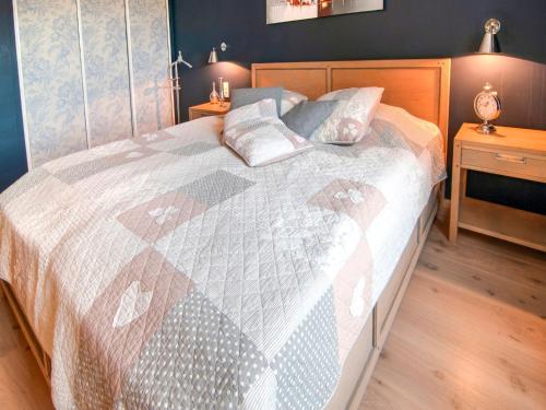 a bedroom with a bed with a quilt on it at Great holiday home in Bastogne with sauna in Le Parque