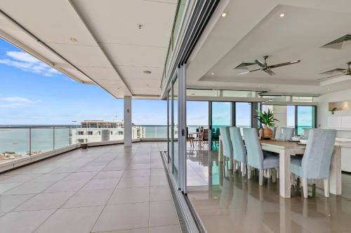 a dining room with a view of the ocean at Premier Penthouse Serene Harbour Views BBQ & Pool in Darwin