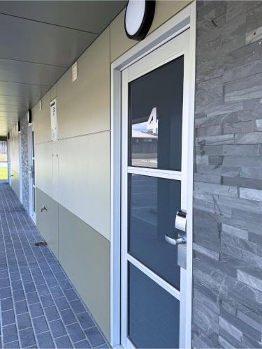 a glass door in a hallway with a window at Brighton Hotel Motel in Pontville