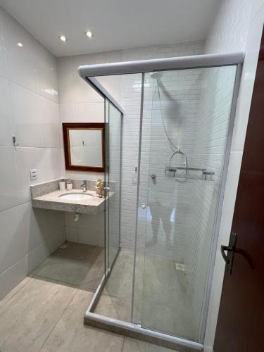a bathroom with a glass shower and a sink at Recanto Serra e Mar in Angra dos Reis