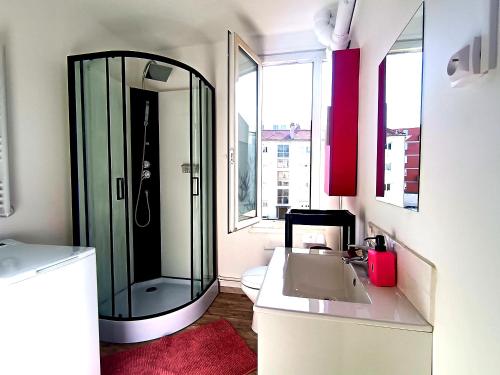 une salle de bain avec une douche en verre et un lavabo dans l'établissement Design Centale Beach, au Havre