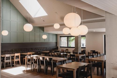 a restaurant with wooden tables and chairs and lights at The Harvest Hotel in Cromwell