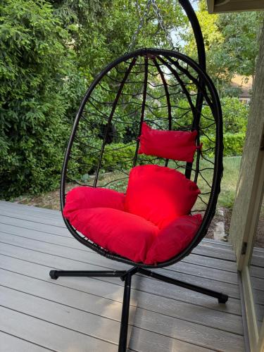 a hanging chair with red pillows on a porch at Redwood Garden in Sacramento