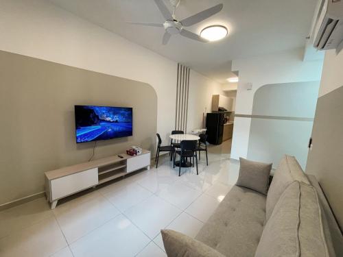 a living room with a couch and a tv on a wall at Central Park Damansara Near KPJ, 1Utama, The Curve by The Homez in Petaling Jaya