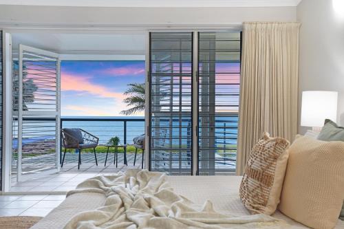 a bedroom with a bed and a view of the ocean at Spacious Beachside Retreat Plunge Pool & Patio in Larrakeyah